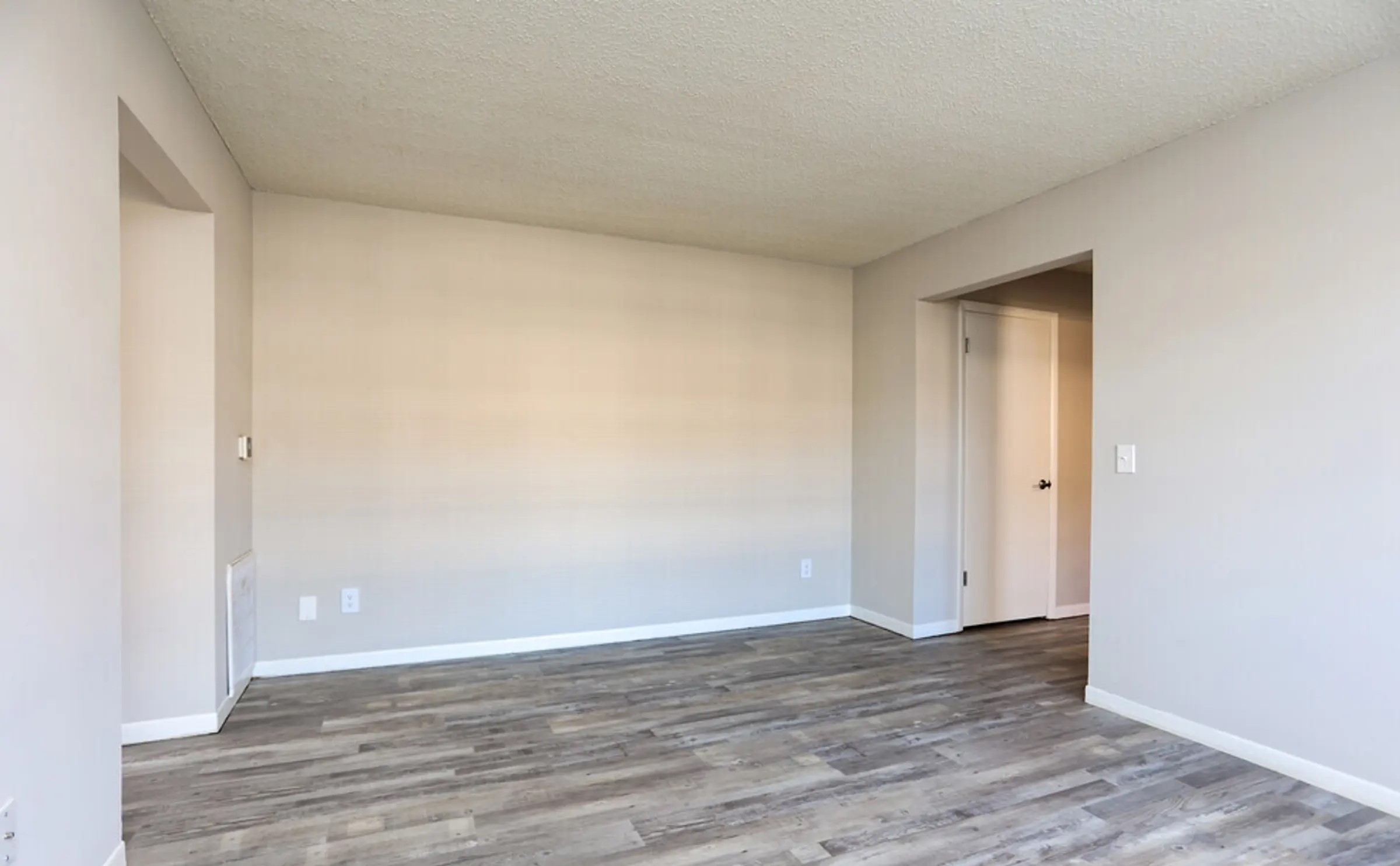 A clean and inviting living area, in our 2 bedroom apartment, featuring beautiful wood-style flooring and neutral, freshly painted walls that can easily match any décor. The space is bright and open, making it ideal for creating a cozy living room. Its seamless flow between rooms offers a sense of spaciousness, making it a perfect canvas for your personal style