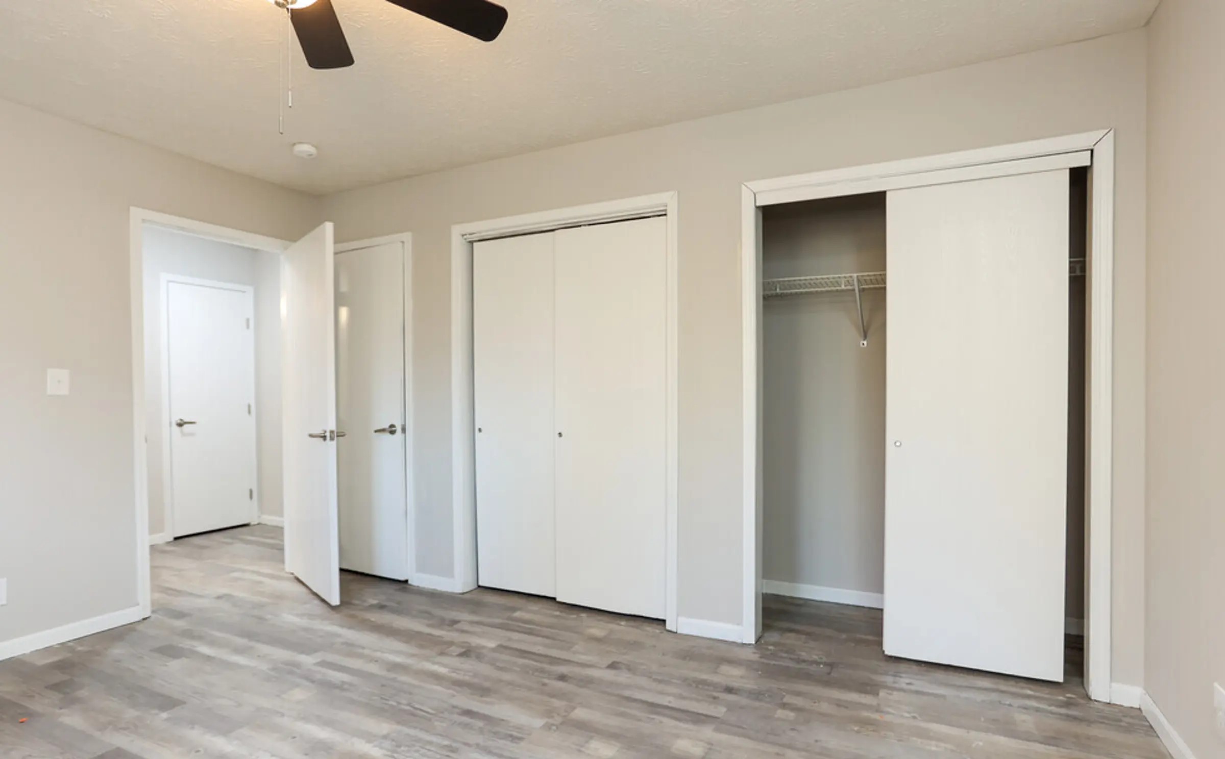 An inviting and well-lit bedroom designed for comfort and organization. The double closet layout provides ample storage space, ideal for keeping your room clutter-free. A ceiling fan adds comfort and airflow, making this room a perfect personal retreat.