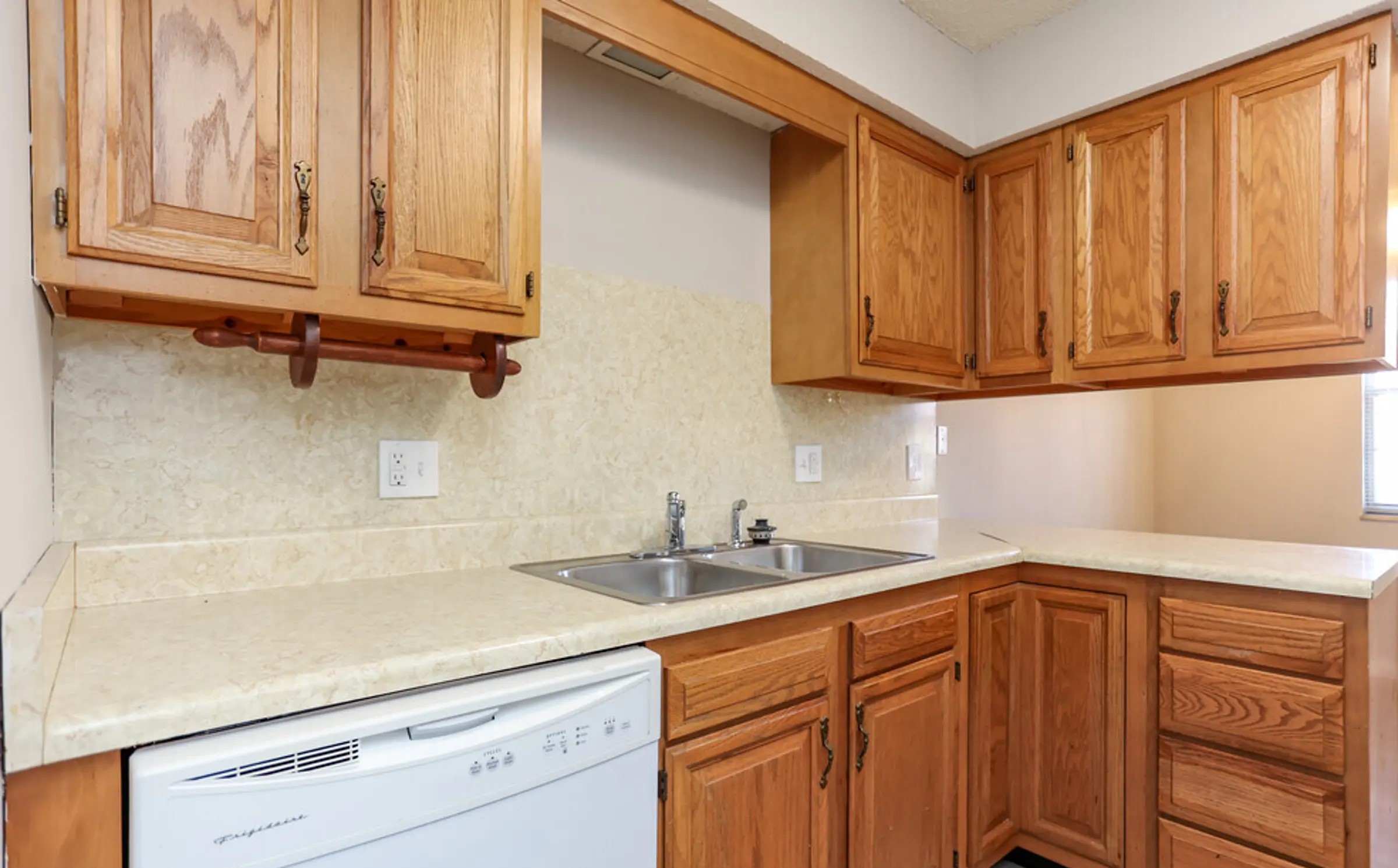 This inviting kitchen, in our 2 bedroom apartment, offers an abundance of cabinetry that provides ample storage for all your cooking essentials. The layout is both efficient and functional, featuring a double sink, built-in dishwasher, and plenty of counter space for prep work. The neutral backsplash and countertop design create a timeless backdrop, making this kitchen ideal for daily meals and special occasions alike