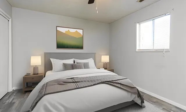 This beautifully staged bedroom, in our 2 bedroom apartment, showcases a serene space ideal for relaxation. The neutral wall tones and soft flooring create a warm and inviting atmosphere, making it easy to personalize. The layout accommodates a large bed and nightstands, providing a cozy and functional space. Natural light flows in from the window, making this room a tranquil haven for rest and comfort.