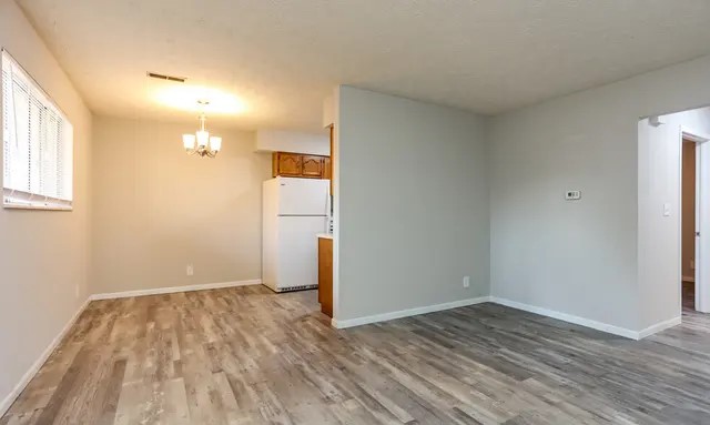 An airy, open layout, in our 1 bedroom apartment, featuring beautiful wood-style flooring that flows seamlessly from the living area into the dining space. The neutral walls and abundant natural light create a welcoming and versatile atmosphere, making it ideal for both relaxing and entertaining. The convenient kitchen area is just steps away, making daily living both functional and comfortable in this charming space